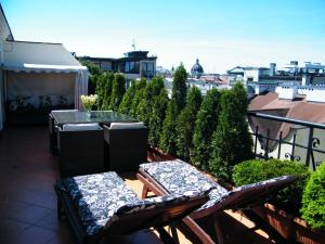 a patio with two chairs and a table on a balcony at Apartament w centrum in Krakow