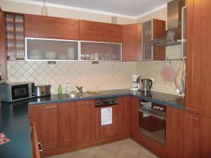 cocina con armarios de madera y encimera en Apartament w centrum, en Cracovia