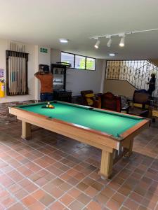 a man standing in a room with a pool table at Hotel Casa Confort in Santa Rosa de Cabal
