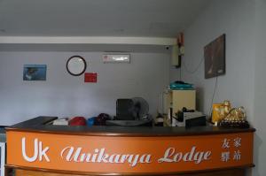 um lobby da embaixada com um sinal no balcão em Unikarya Lodge em Kota Kinabalu