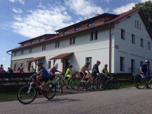 un groupe de personnes faisant du vélo devant un bâtiment dans l'établissement Ekofarma Bílý mrak, à Borohrádek