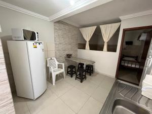 uma cozinha com um frigorífico, uma mesa e cadeiras em Pousada Marques Floripa em Florianópolis