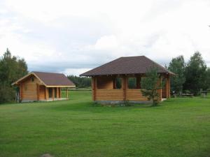 a log cabin in the middle of a field at Kalnakriknas in Dzimtmisa