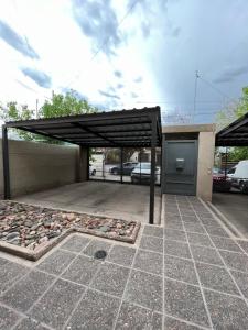 ein Parkplatz mit schwarzem Baldachin und eine Parkgarage in der Unterkunft Hermoso duplex con estacionamiento in Guaymallen