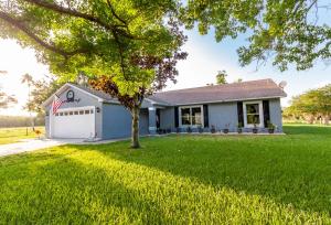 a white house with a tree in the yard at Gorgeous Fully Furnished 2-Bedroom Luxury Villa in Kissimmee