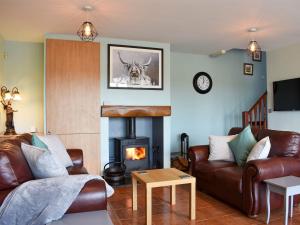 a living room with a couch and a fireplace at Old Stables Cottage in Hunwick
