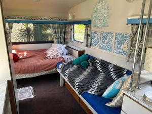 1 Schlafzimmer mit 2 Betten in einem Wohnwagen in der Unterkunft Morepork Rural Oasis in Aongatete