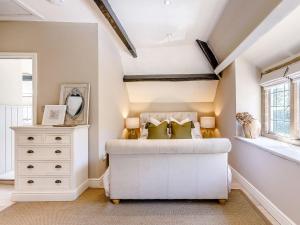 a bedroom with a white bed and a dresser at Hope Cottage in Longborough