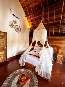 a bedroom with a bed with a mosquito net at Griyatama Bungalow in Nusa Penida