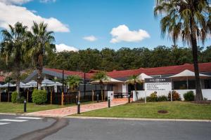 un edificio con palme di fronte a una strada di Salisbury Hotel Motel a Brisbane