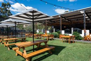 a group of picnic tables and chairs under an umbrella at Salisbury Hotel Motel in Brisbane