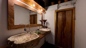 bagno con grande lavandino in pietra e specchio di Chakra Tavern a Bedugul