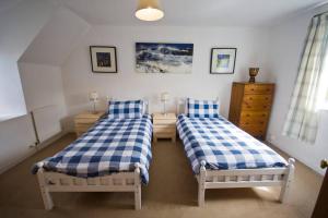 due letti singoli in una stanza con tre tete e tre tete e tre e tre e tre. di Duck Cottage - Pet-friendly Traditional Rural Home a Kilrenny
