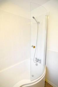 a shower with a glass door next to a toilet at Duck Cottage - Pet-friendly Traditional Rural Home in Kilrenny