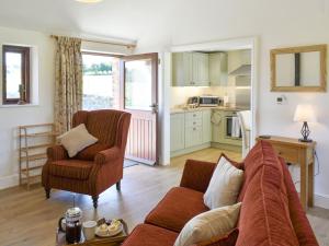 a living room with a couch and a kitchen at Shepherds Den in Crakehall
