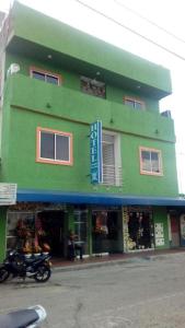 ein grünes Gebäude mit einem Motorrad davor in der Unterkunft Hotel Boutique San Juan in Neiva