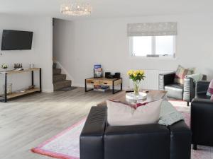 a living room with a couch and a table at Rose Cottage in Dingwall