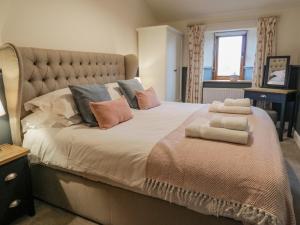 a bedroom with a large bed with pillows on it at Coppa Hill Barn in Carnforth