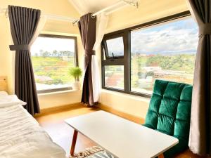 a room with a couch and a table and a window at Bảo Châu Villa & Coffee Đà Lạt in Da Lat