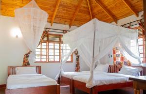 1 dormitorio con 2 camas y mosquitera en Christina House, en Arusha