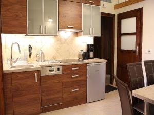 a kitchen with wooden cabinets and a white refrigerator at Vanilla Apartment 3 in Krakow