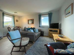 a living room with a couch and a tv at The Old Surgery in Kinlochbervie