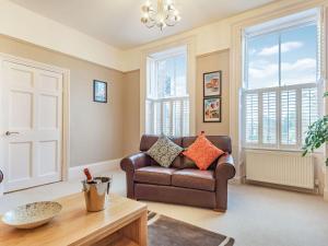 a living room with a couch and a table at Bank House Apartment in Newnham