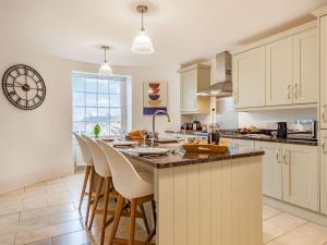 a kitchen with a large island with bar stools at Bank House Apartment in Newnham