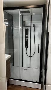 a shower in a bathroom with a phone in it at Embrun - Appartement 4/6 personnes avec extérieurs in Embrun