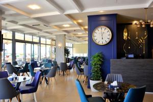 a restaurant with tables and a clock on a wall at Nishan Hotel in Amman