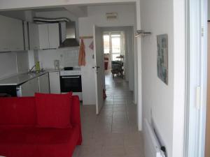 a living room with a red couch and a kitchen at 6 Treti Mart street 2 floor in Primorsko