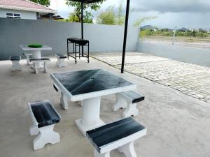 a picnic table and benches with an umbrella at MyHomestay07 in Kangar