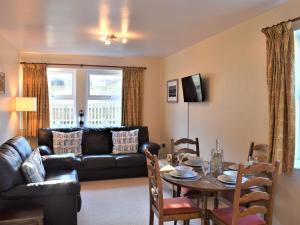 ein Wohnzimmer mit einem Tisch und einem Ledersofa in der Unterkunft Beautiful Cottage In Alnwick With 2 Bedrooms And Wifi in Alnwick