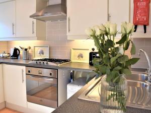a kitchen with a vase of flowers on a counter at Beautiful Cottage In Alnwick With 2 Bedrooms And Wifi in Alnwick