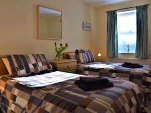una camera d'albergo con due letti e uno specchio di Beautiful Cottage In Alnwick With 2 Bedrooms And Wifi ad Alnwick