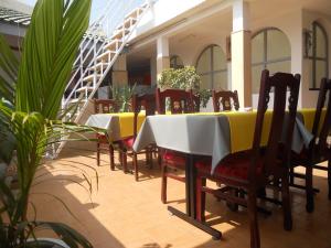 a row of tables and chairs in a restaurant at Maison d'hôtes Opanoramic in Dakar