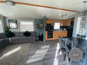 a living room with a couch and a table at Golden Palm Resort - Palm Grove 3 - Pet friendly & WiFi - Meadow Lakes Caravan & Lodge Hire in Skegness