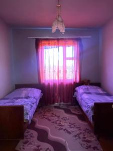 sypialnia z 2 łóżkami i oknem z różowymi zasłonami w obiekcie Rural Treasure w Garni