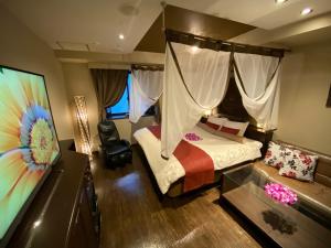 a hotel room with a bed and a tv at Hotel Bali An Resort Nambadotonbori in Osaka
