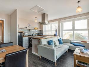 a kitchen and living room with a couch and a table at The Perch-uk37325 in Cromer