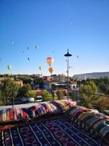 einen Blick auf Heißluftballons, die über eine Stadt fliegen in der Unterkunft Azalea Terrace Hotel in Goreme