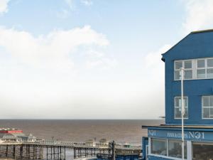 a blue building with the ocean in the background at The Perch-uk37325 in Cromer