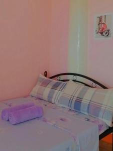 a bedroom with a bed with purple sheets at J&J Tourist Inn in Panglao