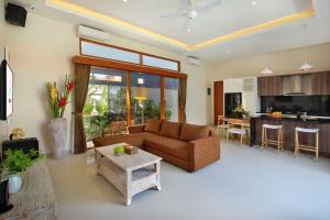 a living room with a couch and a table at Holl Villa by Wildflower Group in Legian