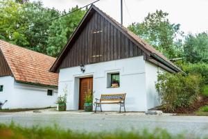 eine Bank, die vor einem weißen Gebäude sitzt in der Unterkunft Winzerhof Küssler - Weinviertel in Stillfried