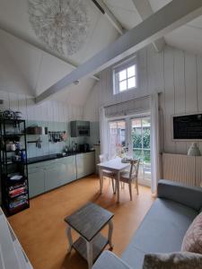 a living room with a table and a kitchen at Bed en breakfast Onder aan de dijk in Warder