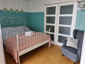 a bedroom with a bed and a chair at Bed en breakfast Onder aan de dijk in Warder