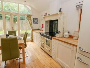 a kitchen with a table and a stove top oven at Lower Sketty Green Lodge in Swansea