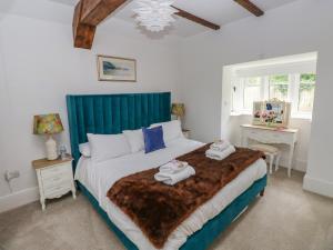a bedroom with a large bed with towels on it at Lower Sketty Green Lodge in Swansea