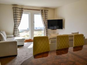 a living room with a couch and a tv at Sandy Feet - Uk39822 in Portpatrick